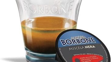 Caffè Borbone in capsule compatibili con Nespresso, Lavazza, Bialetti e Dolce Gusto disposte elegantemente accanto a una tazzina di espresso napoletano